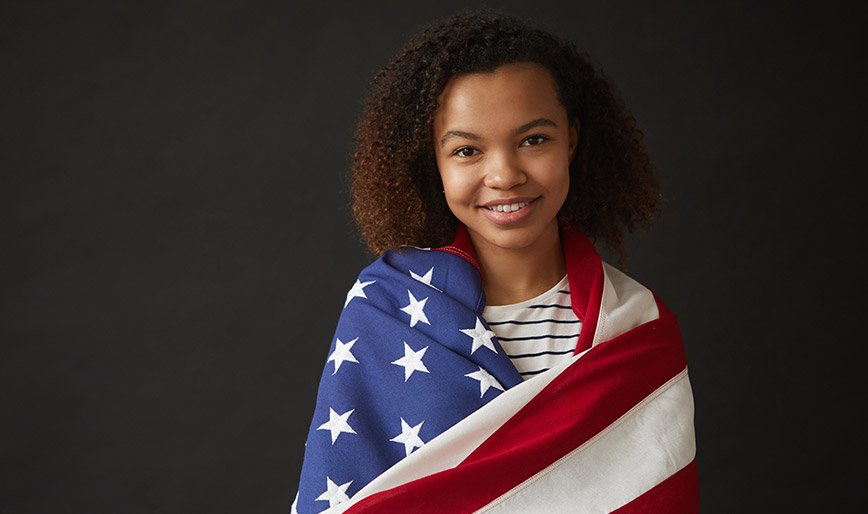 young-african-woman-holding-american-flag-on-black-6DPEZ6Z